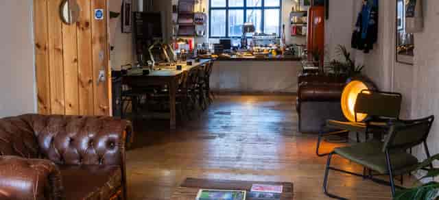Industrial-chic lounge with communal seating for creative workshops and corporate meetings.