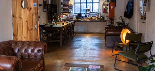 Industrial-chic lounge with communal seating for creative workshops and corporate meetings.