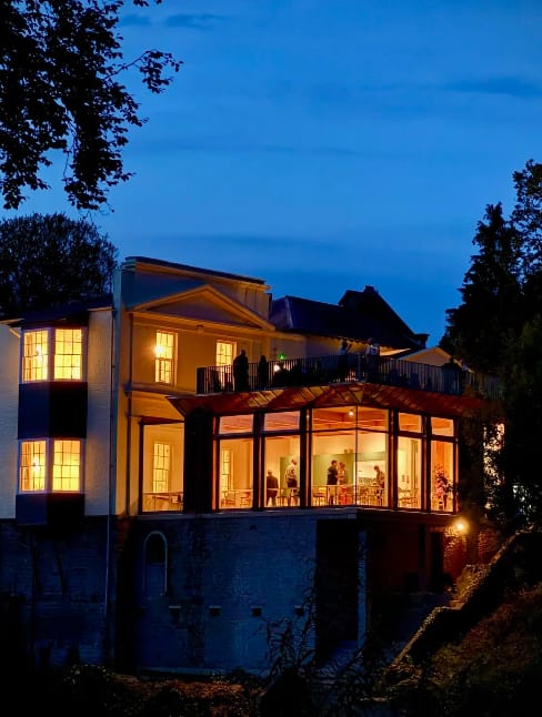 The Club House multi-level venue at twilight with open-air terrace for events and networking.