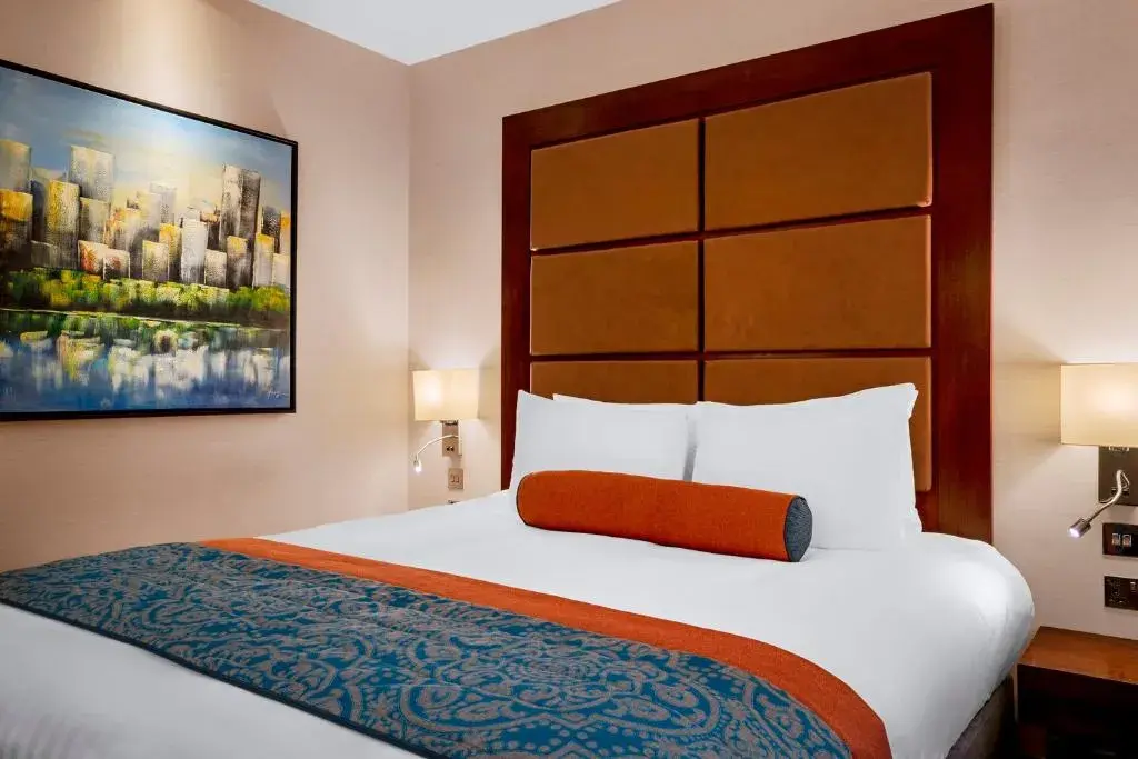 Cozy hotel room at Leonardo Royal Hotel London St Pauls, ideal for event attendees.