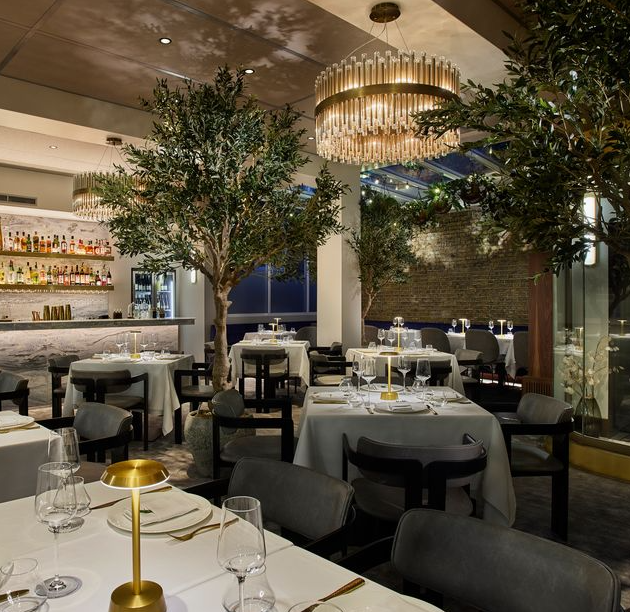 Upscale dining venue with lush biophilic decor, perfect for corporate dinners and networking events.