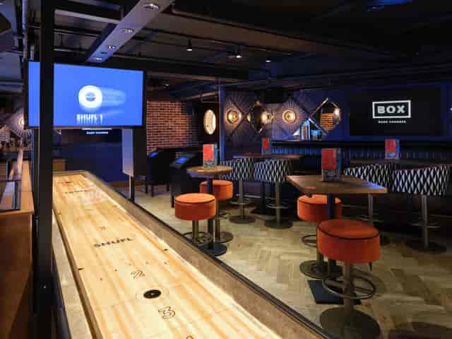 Modern event space at BOX Piccadilly with shuffleboard, ideal for networking and team-building.
