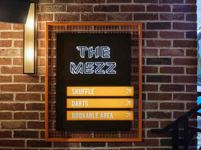 Vibrant directional sign at BOX Piccadilly's Mezzanine for social events and team-building.