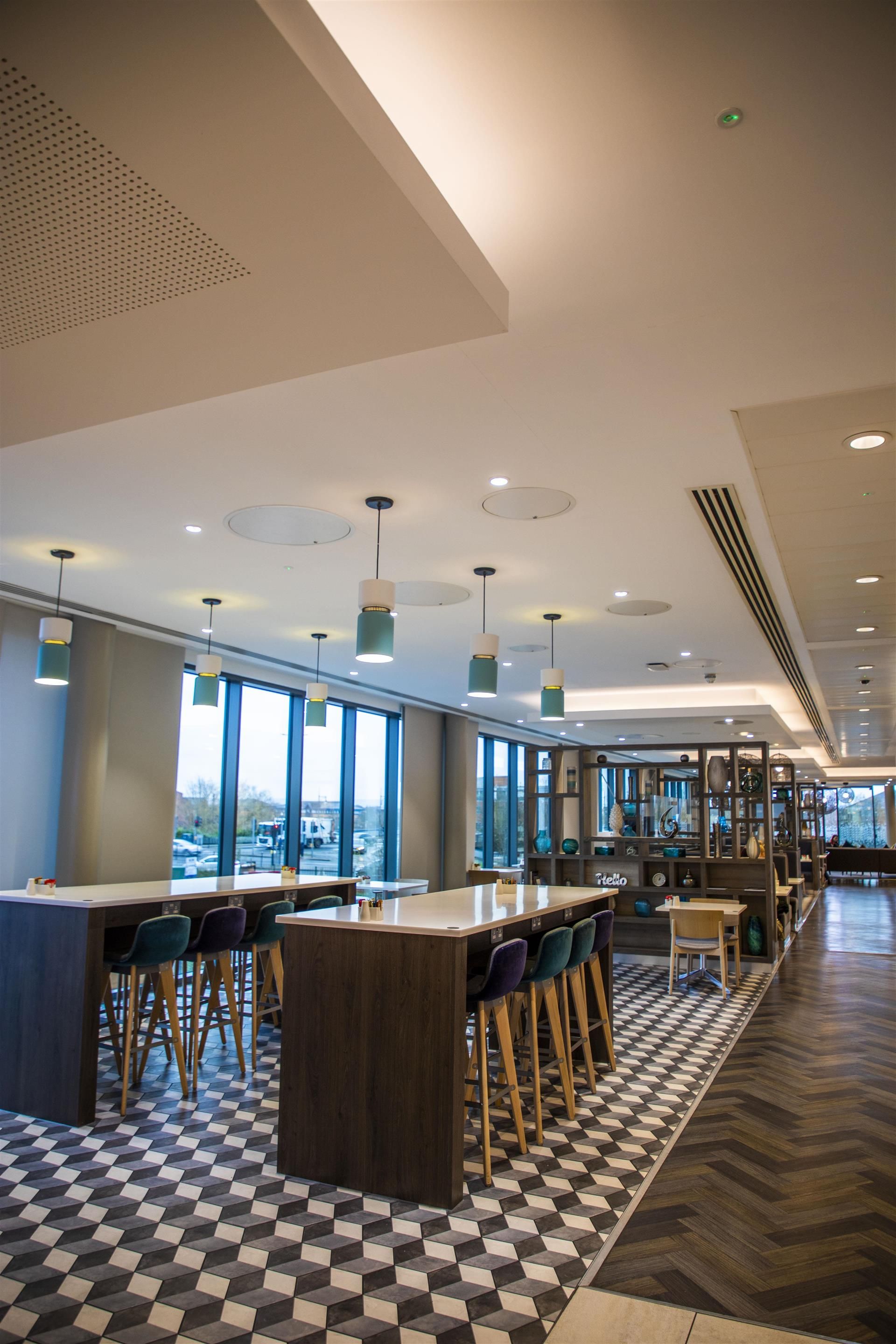 Modern event space with natural light, ideal for networking and workshops at Hampton by Hilton.