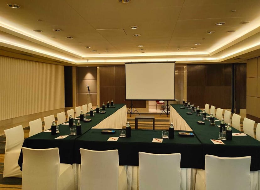 Modern meeting room with U-shaped tables, ideal for workshops and strategic meetings.