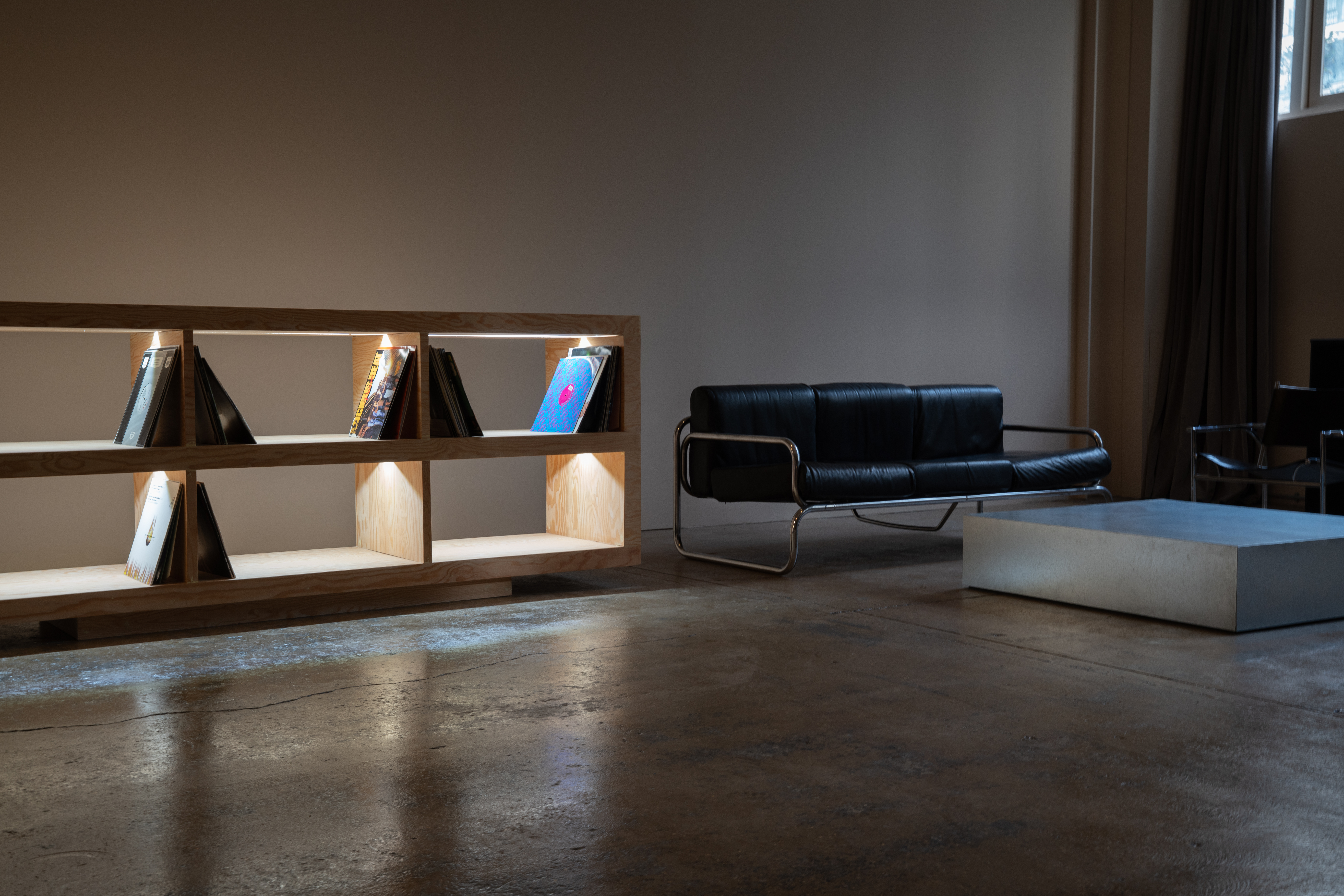 Modern photography studio meeting space with black sofa, ideal for networking events.