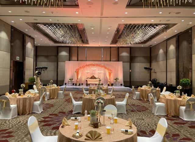 JW Marriott Mumbai Sahar Royal Ballroom wedding reception with elegant stage and champagne linens.