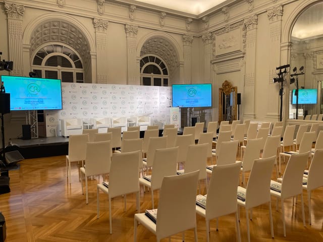 Theater-style setup in Royal Space Rome ballroom with AV displays for executive presentation.