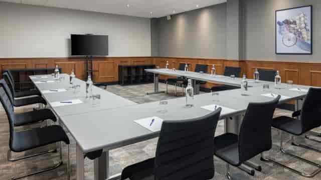 Modern Hilton Newcastle meeting room with U-shaped tables for professional gatherings.