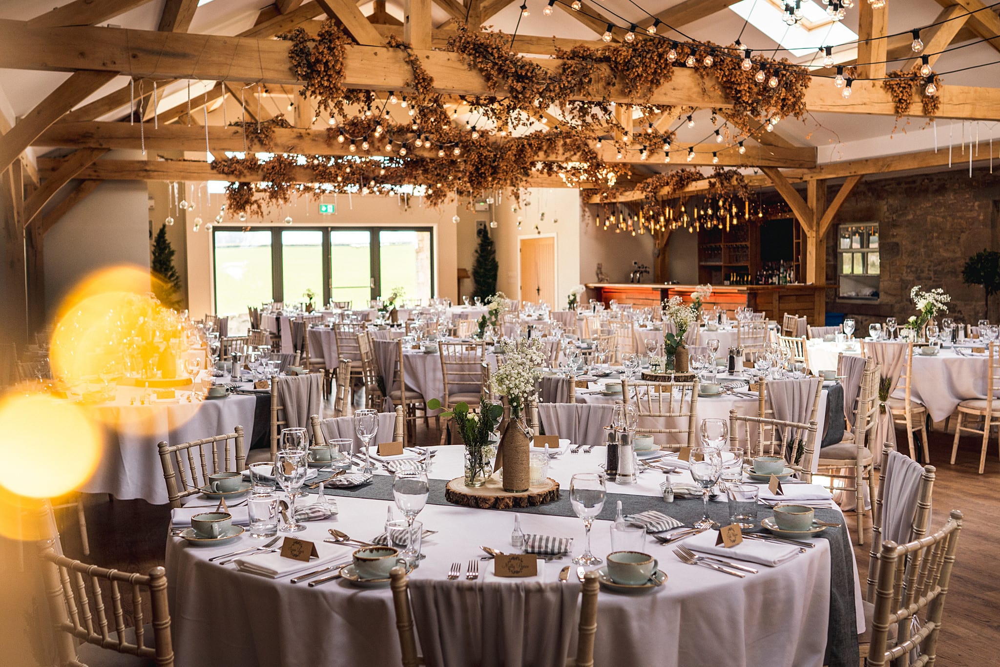 Rustic-chic Chipchase Castle wedding reception with timber beams.