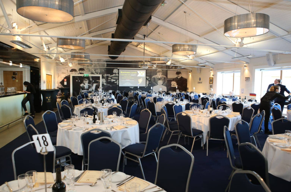 Industrial banquet venue at Lansdowne FC with round tables for corporate dinners and social events.