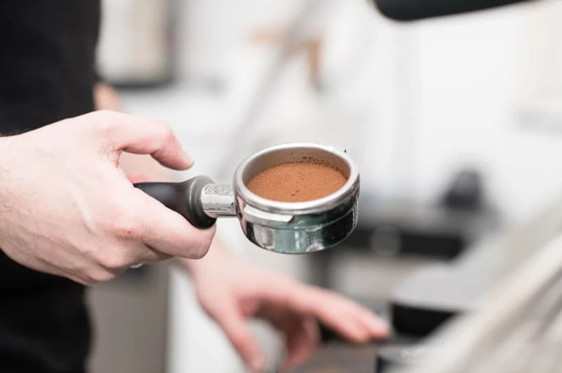 Freshly prepared espresso portafilter for corporate events and professional catering services.