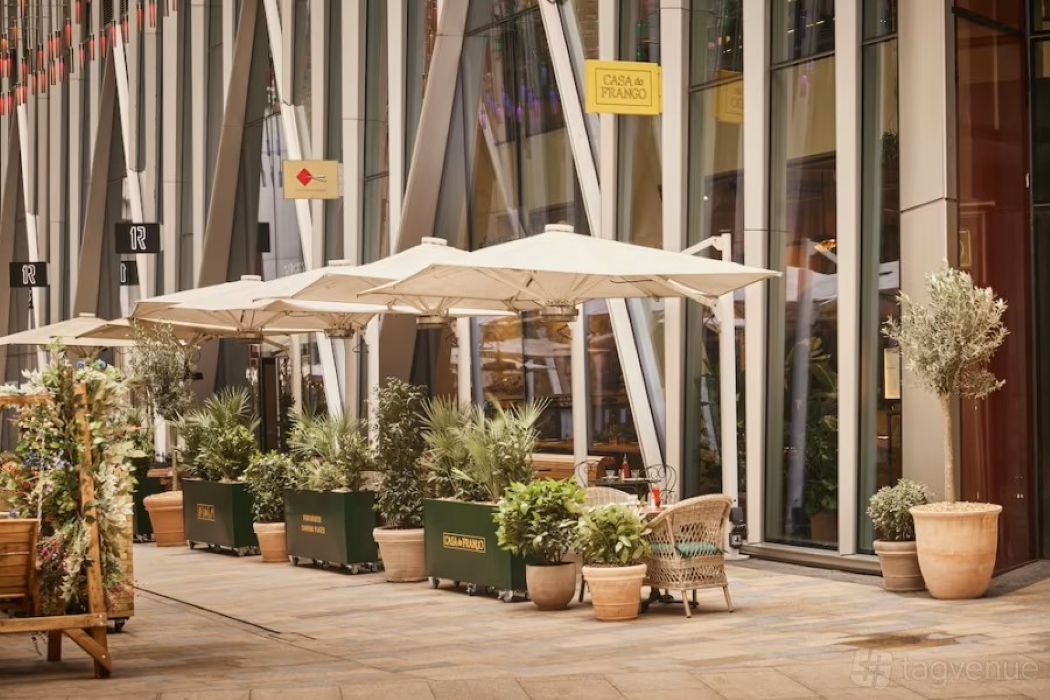 Outdoor event space with umbrellas at Casa do Frango Victoria for casual meetings and networking.