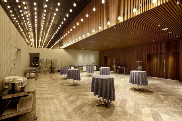 Spacious event venue in Aloft New Delhi with round tables for networking and receptions.