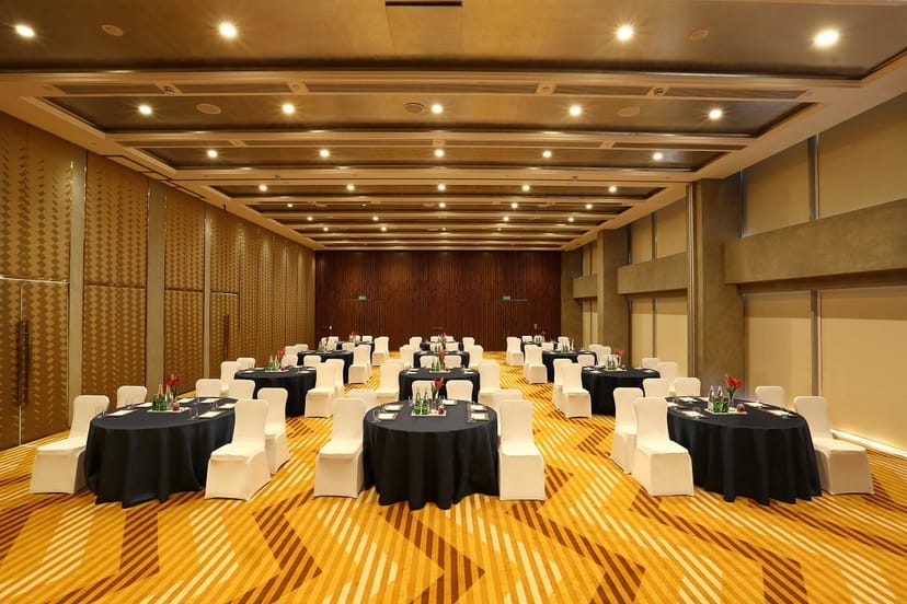 Elegant event space in Aloft New Delhi with round tables, ideal for corporate meetings and gatherings.