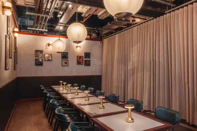 Stylish private meeting room in Arcade Battersea with round pendant lights, ideal for brainstorming.