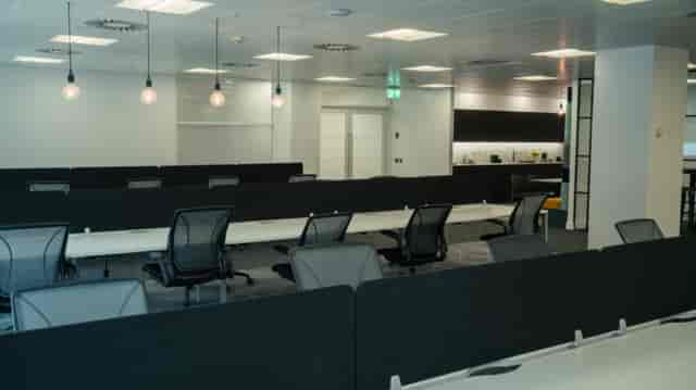 Modern open office space with adjustable workstations for corporate events and workshops.