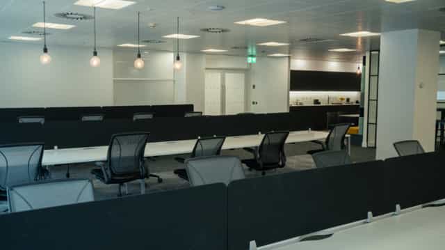 Modern open office space with adjustable workstations for corporate events and workshops.