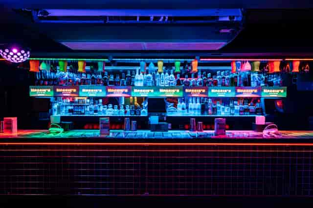 Vibrant bar setup for social gatherings with colorful lighting at Maggie's venue.