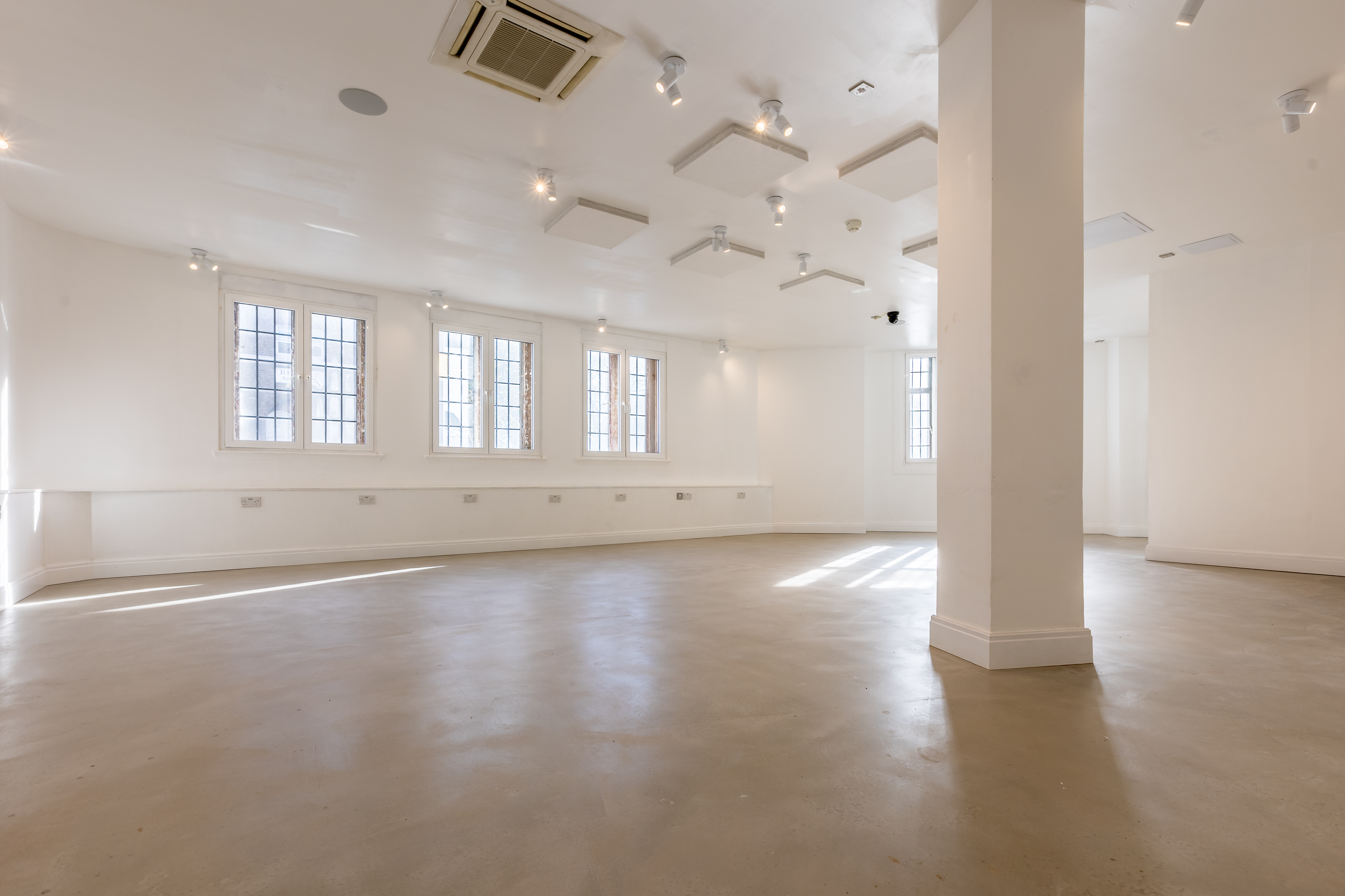 Modern event space with high ceilings and natural light for meetings and workshops.