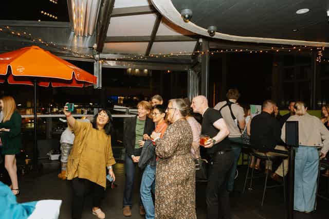 Networking event at The Reveley Boardwalk with string lights and lounge seating.