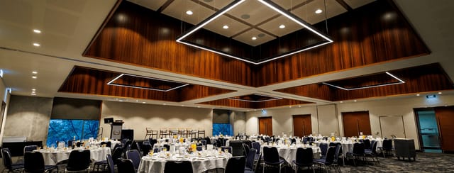Elegant ballroom with geometric lighting for upscale corporate gala dinners and social events.