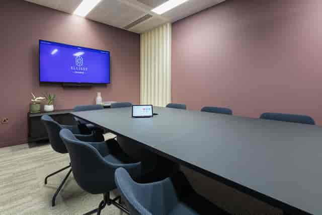 Modern huddle room for executive briefings and hybrid meetings with ergonomic seating.
