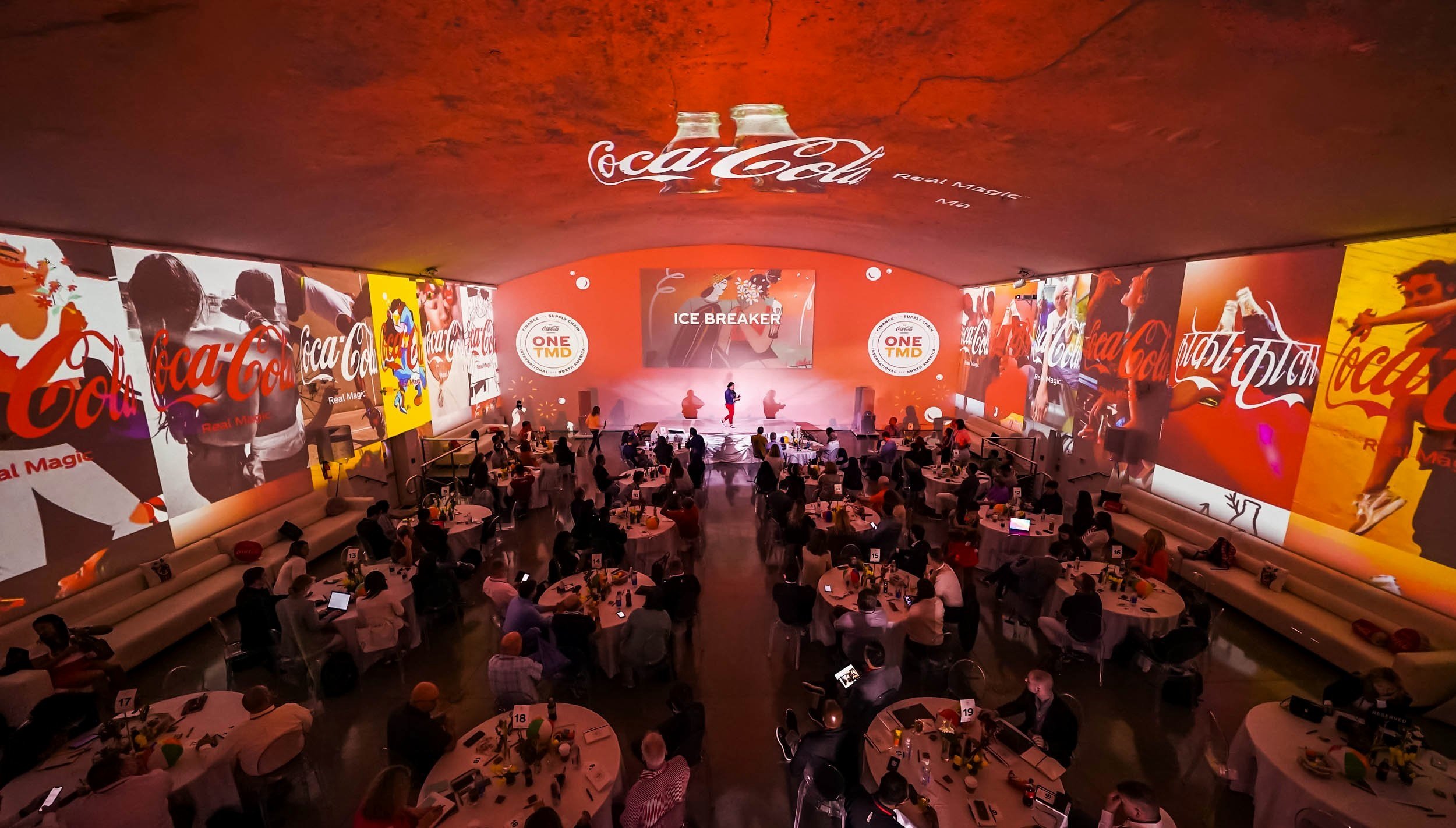 Vibrant conference setting with stage and round tables at Coastal Env Centre.