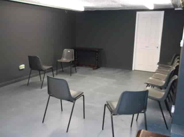 Minimalist meeting space with black walls for workshops and brainstorming sessions.