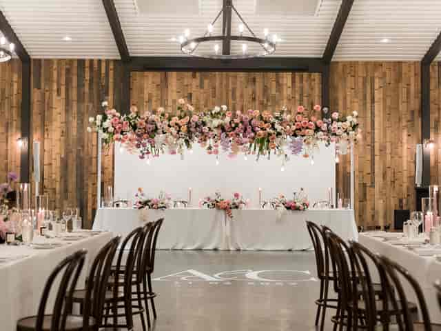 Sandalera Room wedding reception with overhead floral installation and monogram branding.