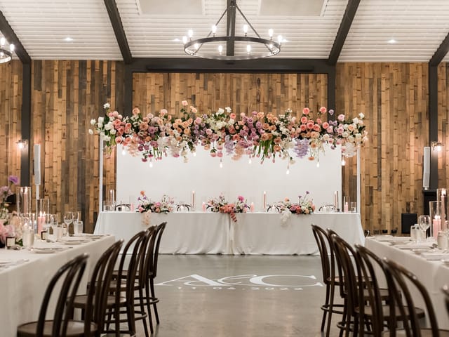 Sandalera Room wedding reception with overhead floral installation and monogram branding.
