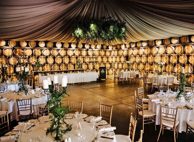 Sandalera Room gala dinner with draped ceiling and wine barrel wall for corporate events.