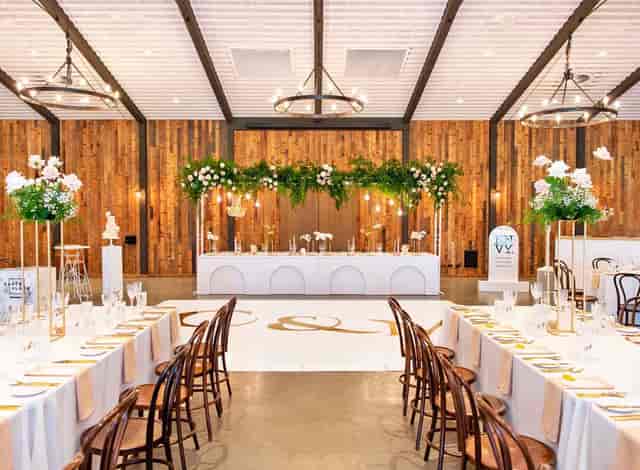 Rustic-chic Hill House event with overhead floral installation and long tables for gala dinner.