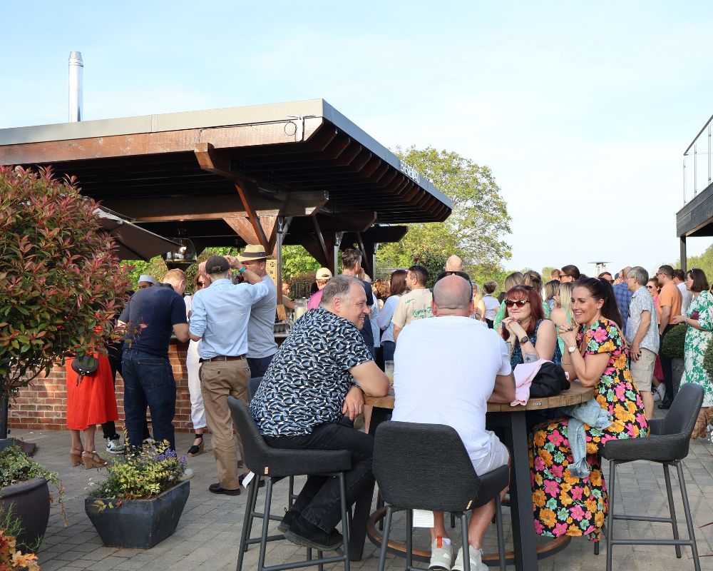 The Terrace at Cambridge Country Club: Outdoor networking reception with covered bar seating.