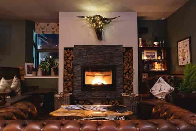 Cozy lounge with fireplace at Ben Cruachan Inn, ideal for gatherings and retreats.