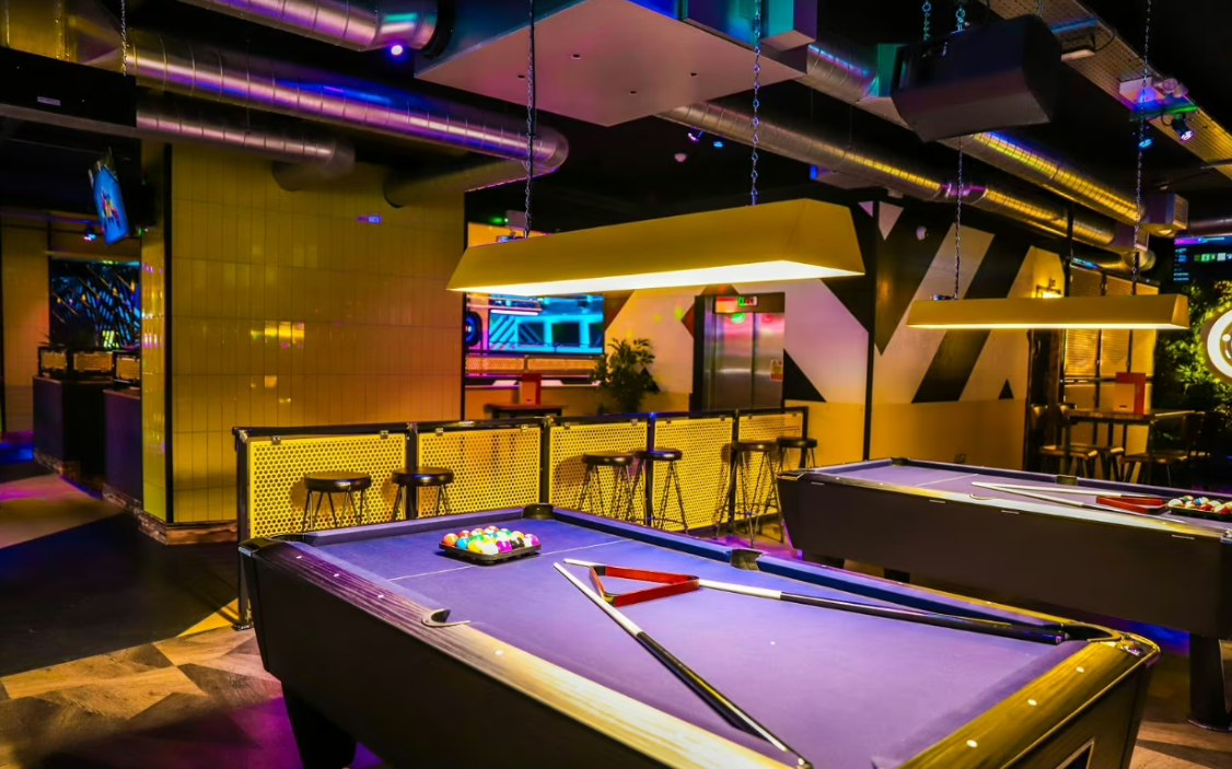 Vibrant event space with stylish pool tables in King Pins, ideal for networking and team-building. - Banner