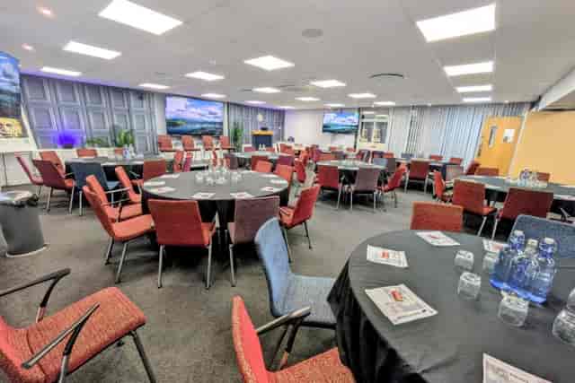 Exhibition Hall meeting room with round tables for corporate workshops and conferences.