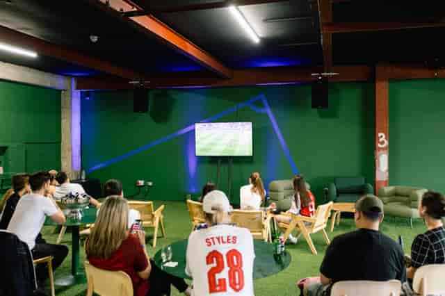 Industrial-chic sports fan zone with turf flooring for immersive event venue rental.