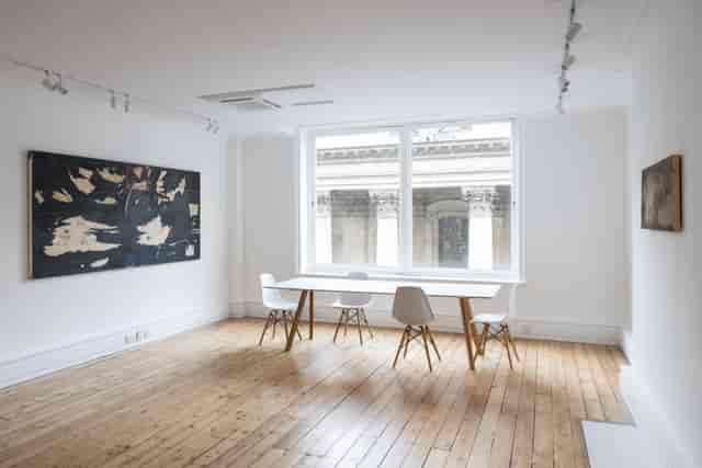Minimalist meeting room with natural light for intimate gatherings and brainstorming sessions.