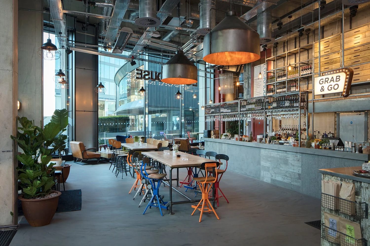 Modern café space for networking events, featuring large windows and ample seating. - Banner