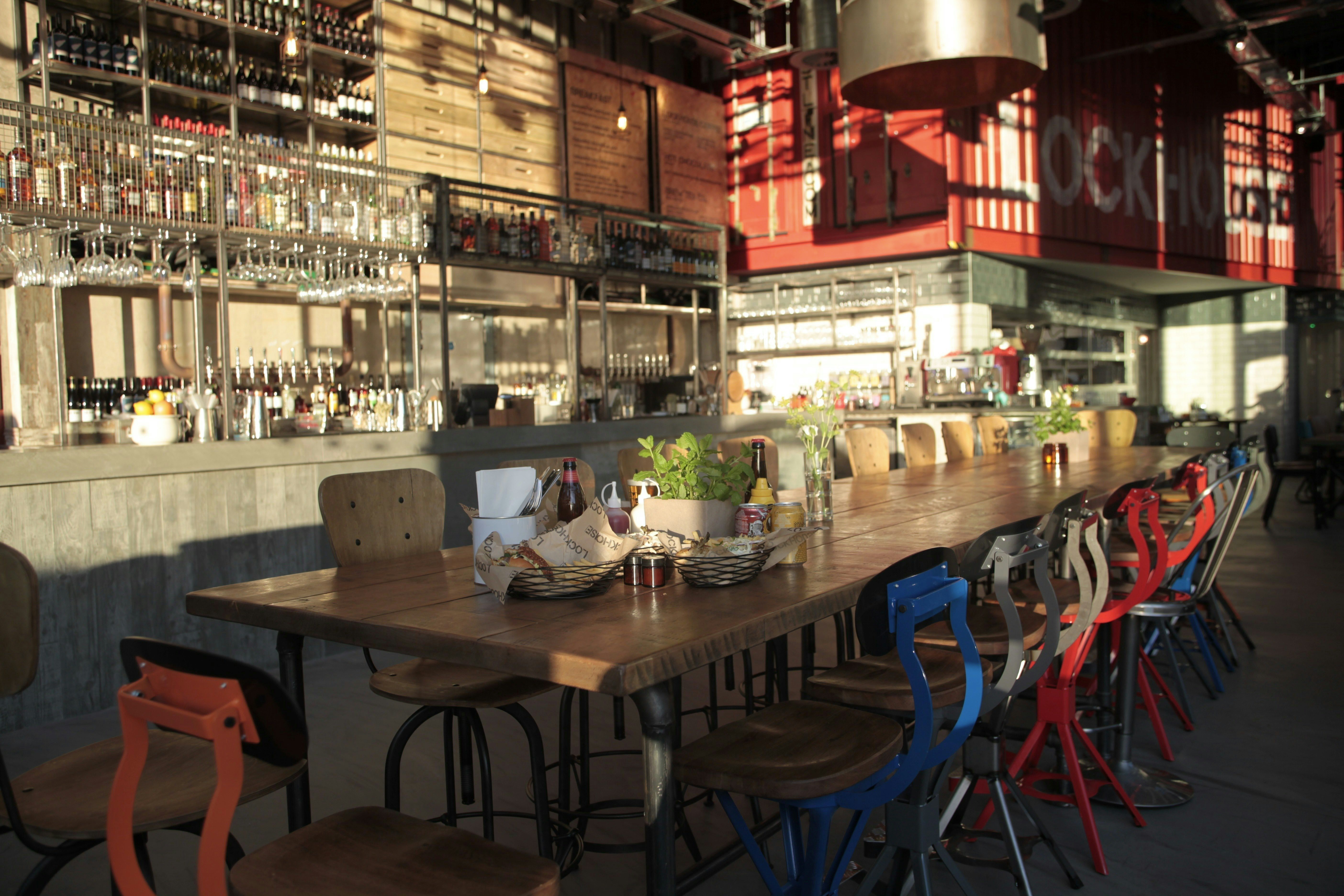 Spacious venue with wooden table, vibrant chairs for events and gatherings in Lockhouse - Banner