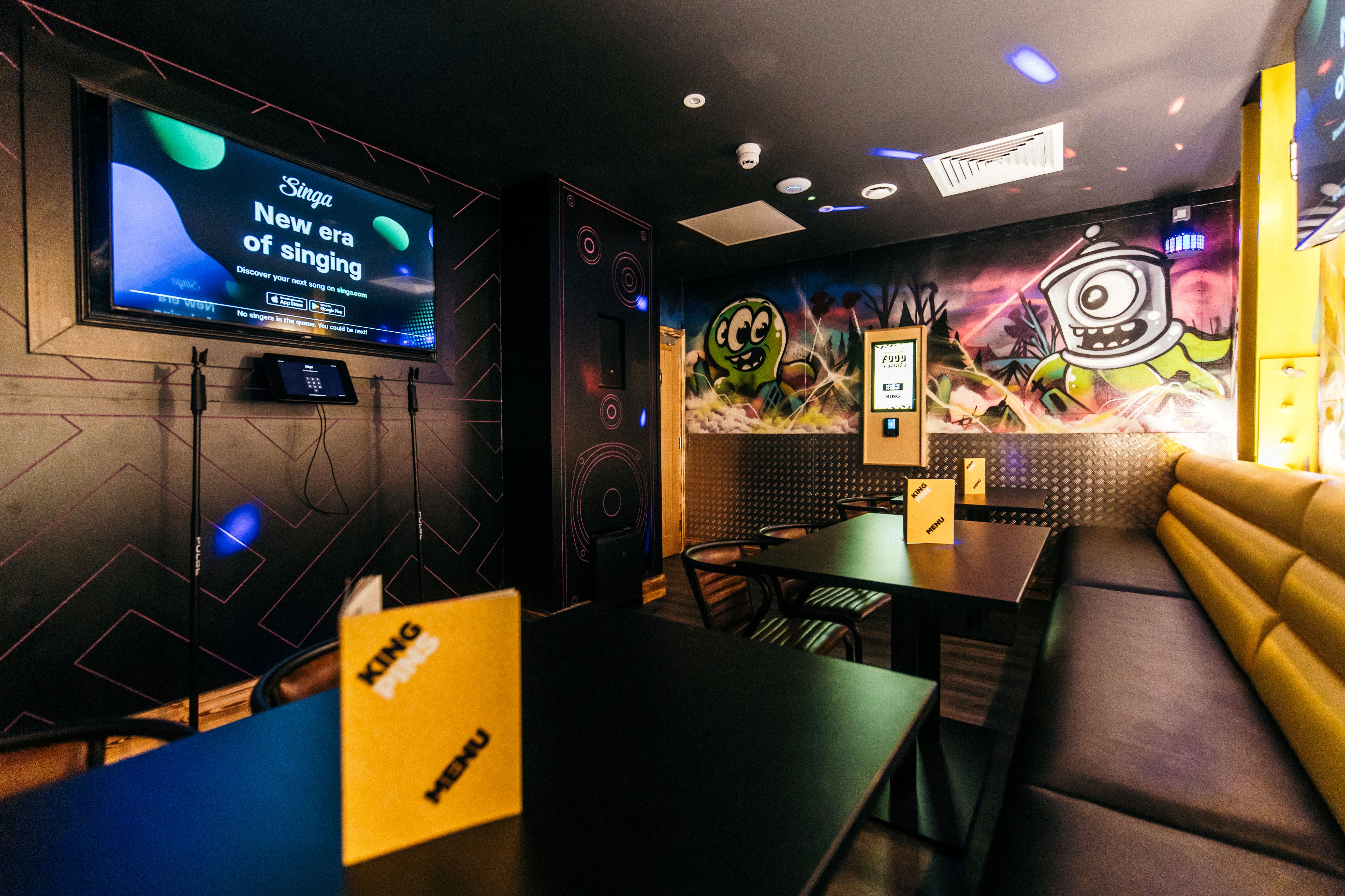 Karaoke room at King Pins Belfast, vibrant decor for team-building and social events.