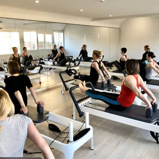 Reformer Pilates studio with mirrored walls, perfect for wellness retreats and corporate events.