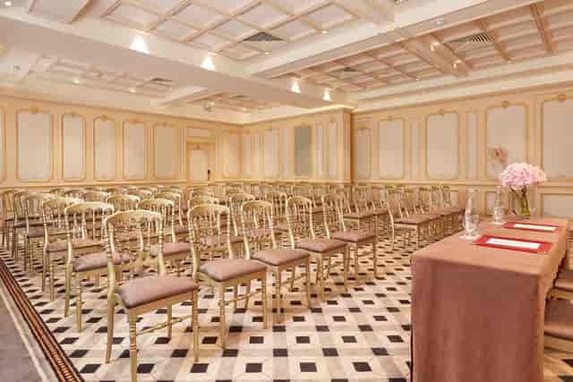 Salon Marsan meeting room with gold chairs for corporate seminars and formal presentations.