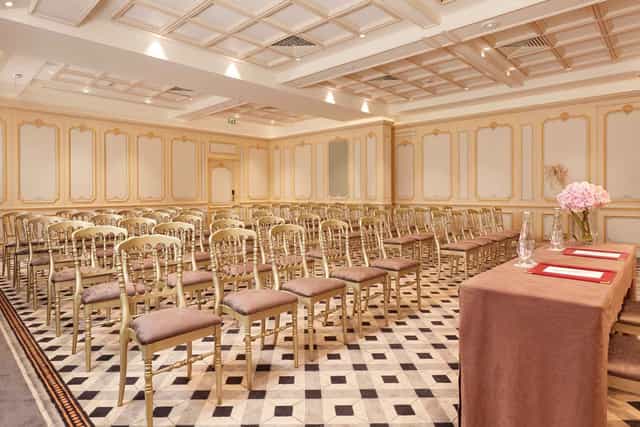 Salon Marsan meeting room with gold chairs for corporate seminars and formal presentations.