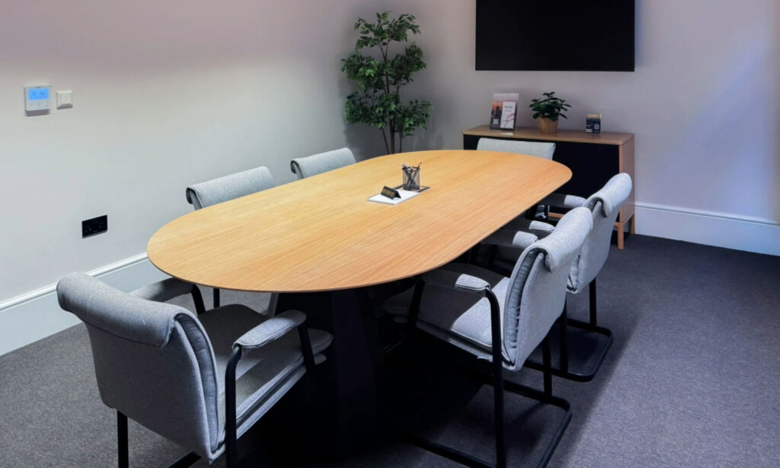 Modern meeting room with oval table, perfect for collaboration and presentations.