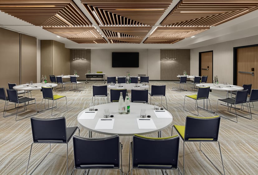 Modern meeting room with circular tables at Courtyard by Marriott Paris, ideal for events.