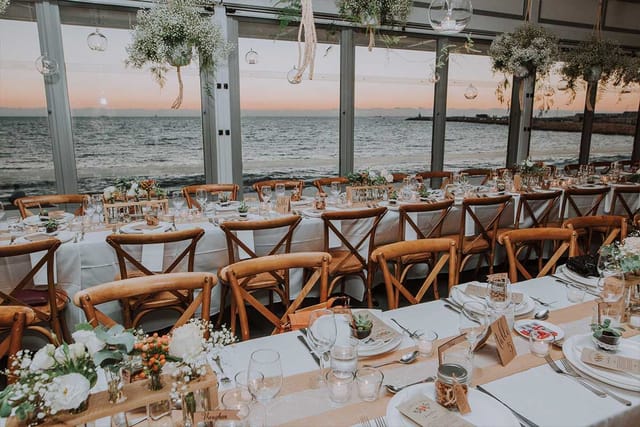 Beachfront venue with sunset views and minimalist decor for upscale corporate or social events.