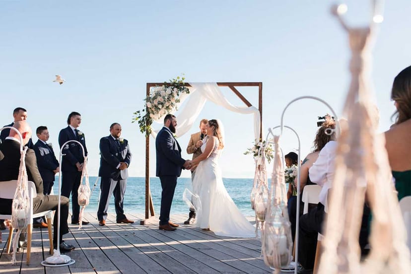 Coastal wedding ceremony with timber archway at Bathers Beach House oceanfront venue.