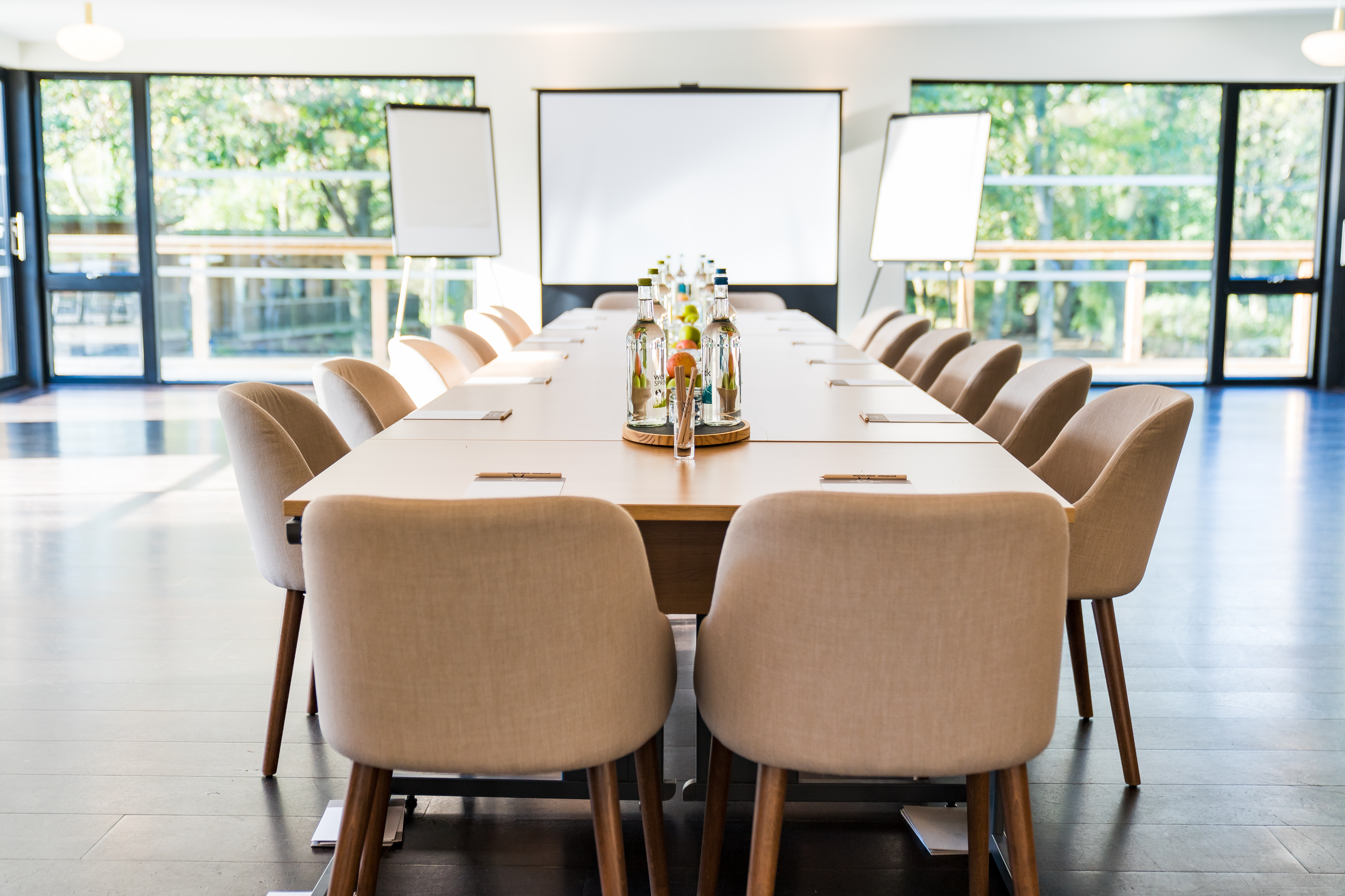 Modern meeting space with wooden table, perfect for collaboration and brainstorming events. - Banner